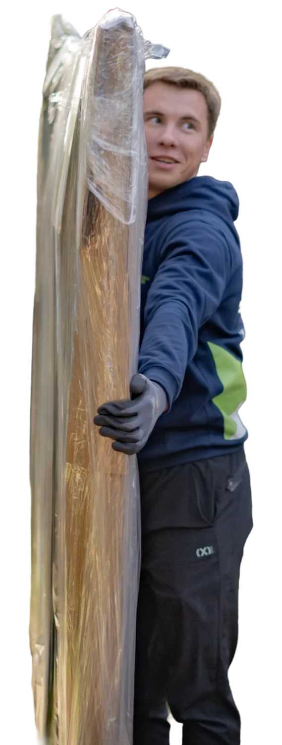 Best California Movers crew member carrying a shrink-wrapped mattress out of an apartment